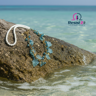 Jewelry set on a rock with ocean background, Resist2it logo visible