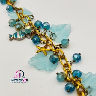 Close-up of handmade beach necklace with Czech glass beads and acrylic leaves
