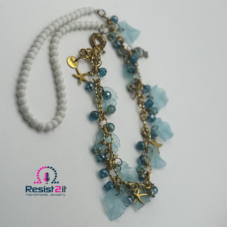 Necklace with blue beads and star charms on a white background, featuring Resist2it branding.