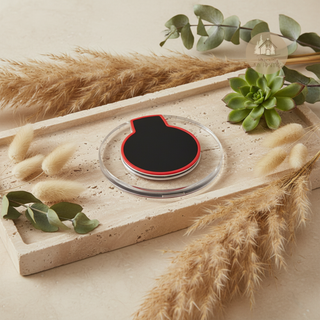 AURA™ Wireless Charger on a travertine stone tray surrounded by pampas grass, eucalyptus and a succulent, warm beige tones