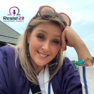 Woman wearing handmade jewelry in blue and purple with gemstones featuring the Resist2it brand