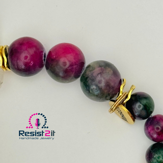 Beaded bracelet with green, purple, and burgundy stone beads and a golden charm of Resist2it