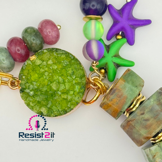 Colorful beaded bracelet with various beads on a white background, featuring the Resist2it Handmade Jewelry logo.