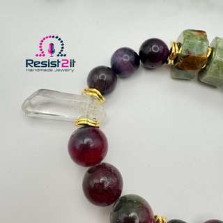 Detail of a handcrafted stone bead bracelet with purple and burgundy beads and a white crystal , featuring the Resist2it brand.