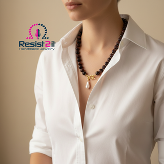 Woman wearing a white shirt with a beaded necklace Desert Pearl™ with 12mm burgundy tiger eye beads, featuring Resist2it jewelry brand. 