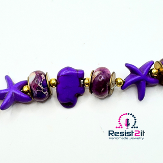 Purple starfish and elephant on handmade PURPLE TIDES™ bracelet with 'Resist2it Handmade Jewelry' logo.
