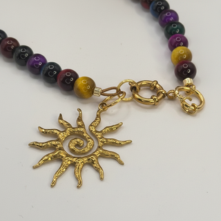 SOLSTICE™ Necklace with a sun-shaped pendant and beaded chain on a white background