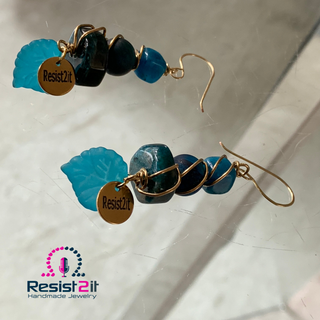 Detail of Resist2it signature charm on handmade blue gemstone earrings
