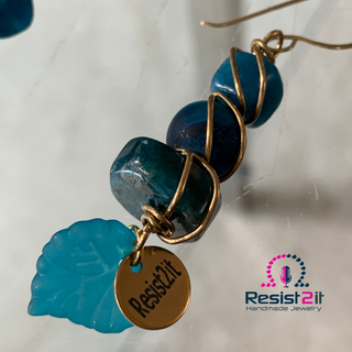 Detail of Resist2it signature charm on handmade blue gemstone earrings