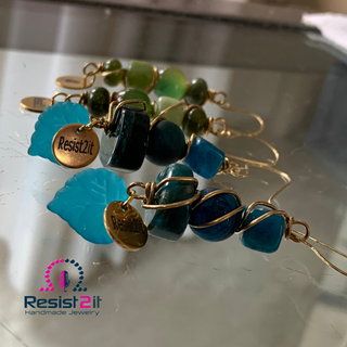 Side view of wire wrapped apatite earrings showing layered gemstone structure with gold Resist2it charm