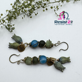 Full view of the pair of Hooked!™ gemstone earrings with blue and green fish charms by Resist2it 