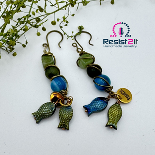 Total view of the two earrings of Hooked!™ with gemstones and fish charms and Resist2it charm earrings