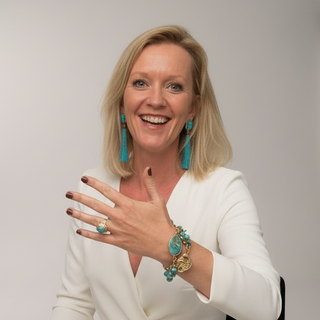 Happy woman in white wearing a Turquoise Beach bracelet by Resist2it