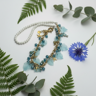 Necklace with blue floral and starfish charms on a white background