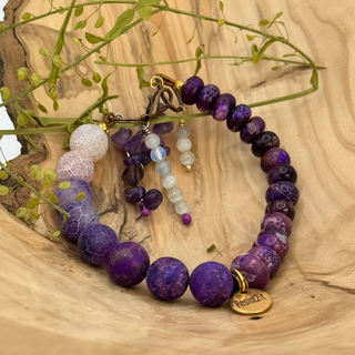 Mixed Feelings™ single purple gemstone bracelet with the white one detached, ready to be worn by a man's or a woman's wrist, featuring the Resist2it brand