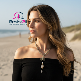 Woman on a beach wearing LABRADORITE MOONLIGHT™ Necklace draped elegantly, highlighting the smoky quartz cone bead and clear quartz druze centerpiece