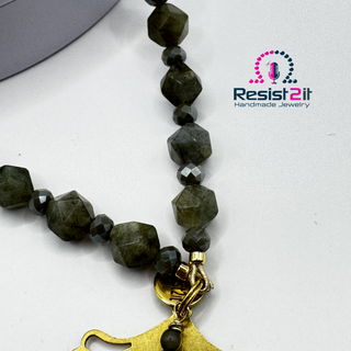 Close-up detail of faceted labradorite beads showing natural iridescent flash and grey moonstone accents, featuring 'Resist2it Handmade Jewelry' logo.