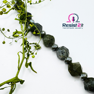 Detail of the Labradorite Moonlight necklace showing faceted labradorite beads with grey Czech faceted glass beads, featuring the Resist2it Handmade Jewelry logo