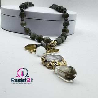 LABRADORITE MOONLIGHT™ Necklace with gray beads and gold accents on a white surface, featuring 'Resist2it Handmade Jewelry' logo.