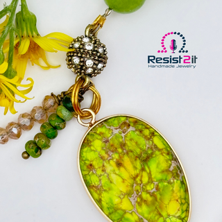 Jewelry with a limegreen pendant and brown beads on a white background, featuring Resist2it Handmade Jewelry logo.