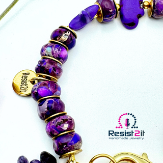 PURPLE TIDES™  beaded bracelet with gold accents on a white background, featuring the Resist2it brand.