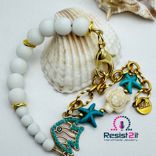 Armband met witte stenen and goudkleurige ketting met turquoide bedels en logo van Resist2it 