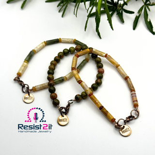 Three beaded bracelets with 'Resist2it' branding on a white background with green leaves.