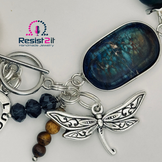 Detail of natural stone beads with silver dragonfly and blue stone connector