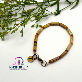 Handcrafted men's bracelet with beige tube beads, a copper clasp, and a charm with a microphone, featuring logo of Resist2it