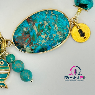 Detail of turquoise connector and natural stone pattern in handmade bracelet with a golden charm with microphone