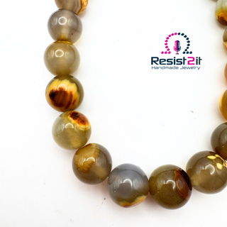 Close-up of the UNSPOKEN™ necklace tiger skin agate beads, featuring the Resist2it Handmade Jewelry brand