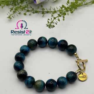Ocean Depth tiger eye bracelet showing gold toggle clasp and Resist2it charm detail
