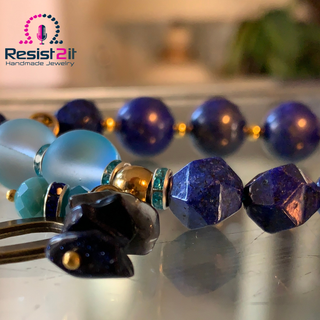 Colorful beaded bracelet with a blurred background featuring 'Resist2it Handmade Jewelry'.