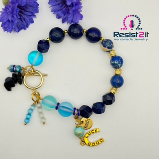 Handmade beaded equestrian bracelet with blue beads and gold charms and Resist2it branding.