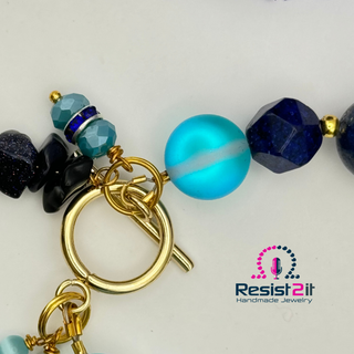 Close-up of a beaded keychain with gold clasp on a white background, featuring the Resist2it brand.